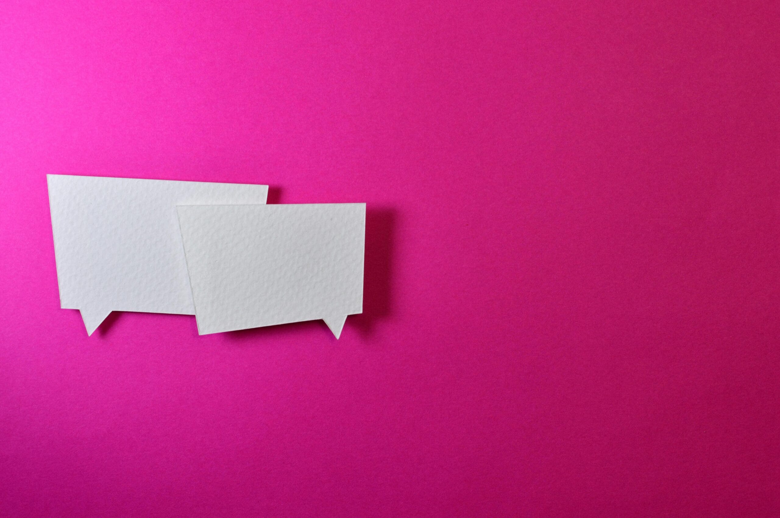 pexels-photo-1111368-1111368 White speech bubbles on a vibrant pink background for communication or design concepts.